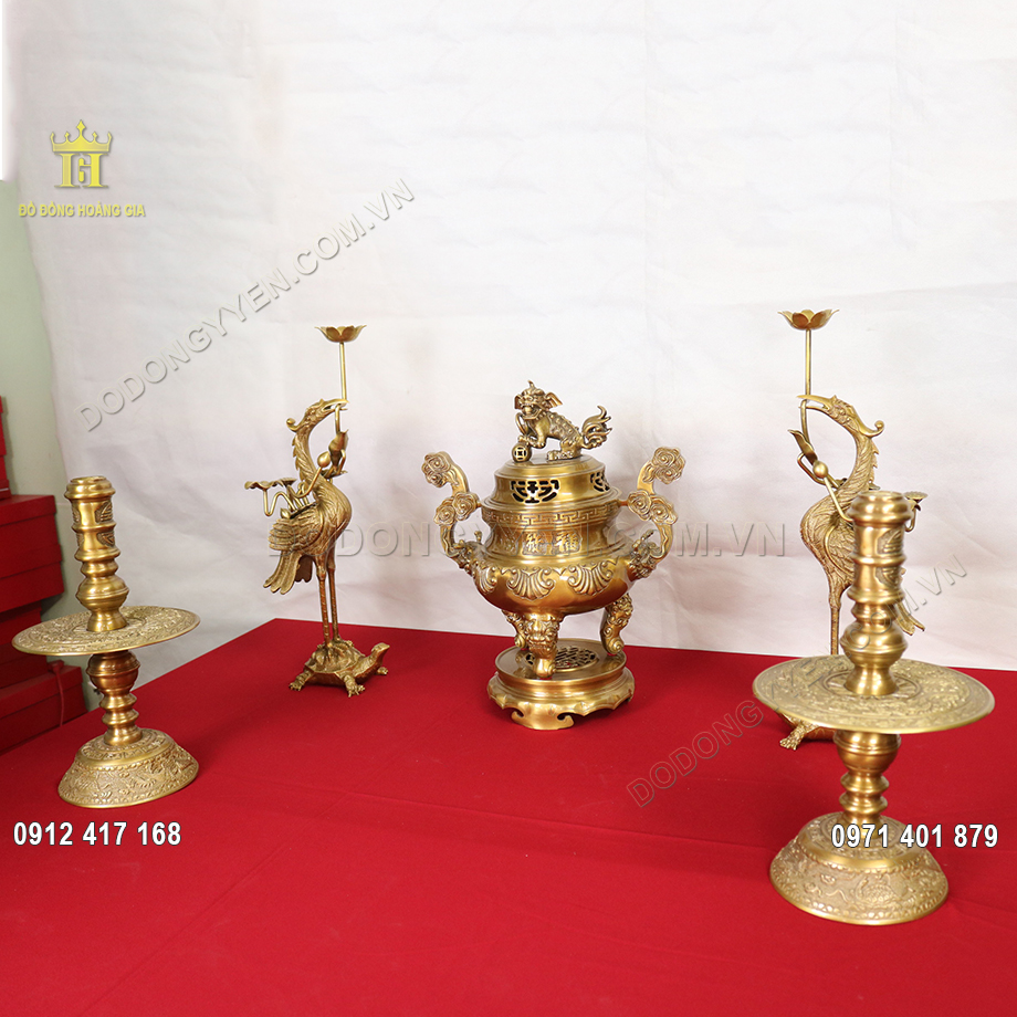 Bộ ngũ sự n&agrave;y bao gồm 1 đỉnh đồng hoa s&ograve;i, hai b&ecirc;n l&agrave; đ&ocirc;i hạc chầu, v&agrave; đ&ocirc;i ch&acirc;n nến bằng đồng v&agrave;ng